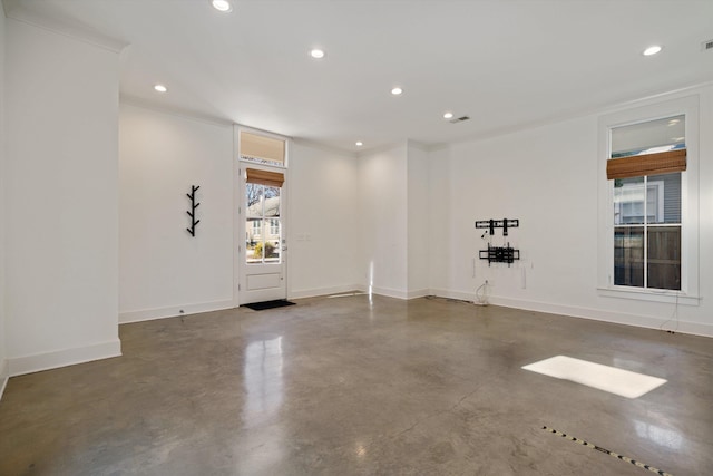 empty room with crown molding and concrete flooring