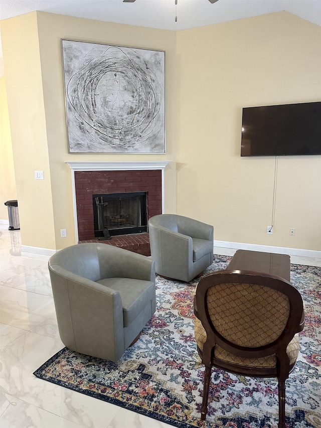 living room with a brick fireplace and ceiling fan