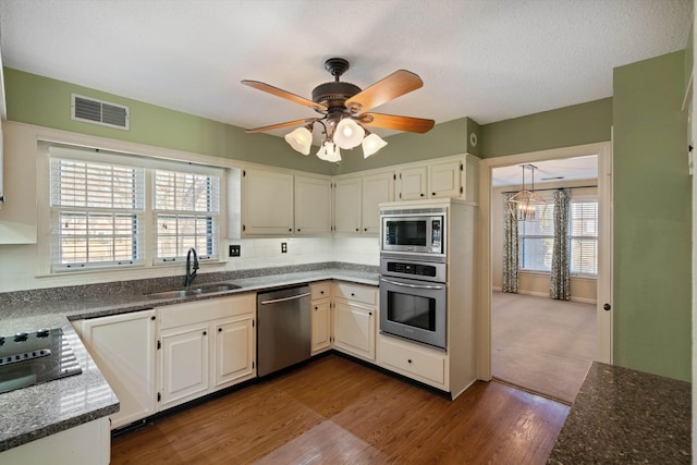 kitchen with sink, white cabinetry, appliances with stainless steel finishes, and a healthy amount of sunlight