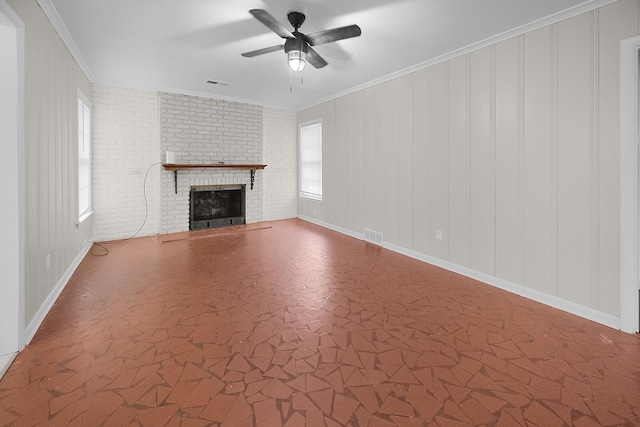 unfurnished living room featuring ceiling fan, a brick fireplace, and crown molding