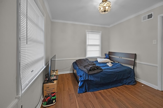 bedroom featuring dark wood-type flooring and crown molding