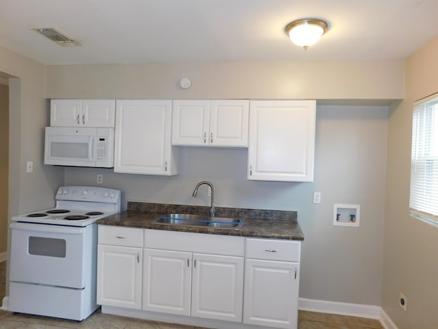 kitchen featuring white cabinetry, sink, white appliances, and light tile patterned floors