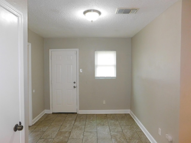 unfurnished room featuring a textured ceiling