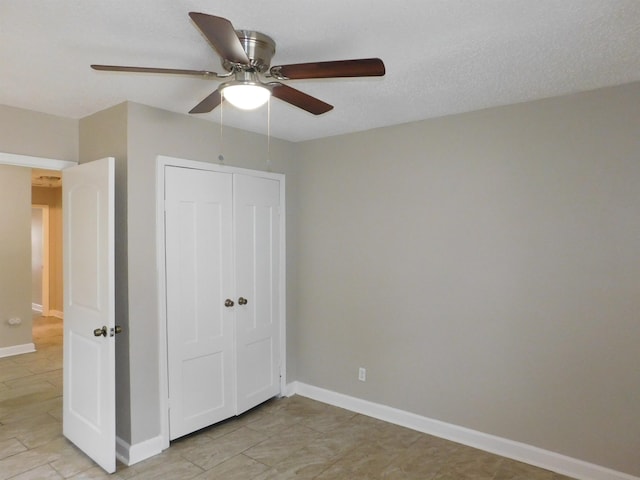 unfurnished bedroom with ceiling fan, a closet, and a textured ceiling