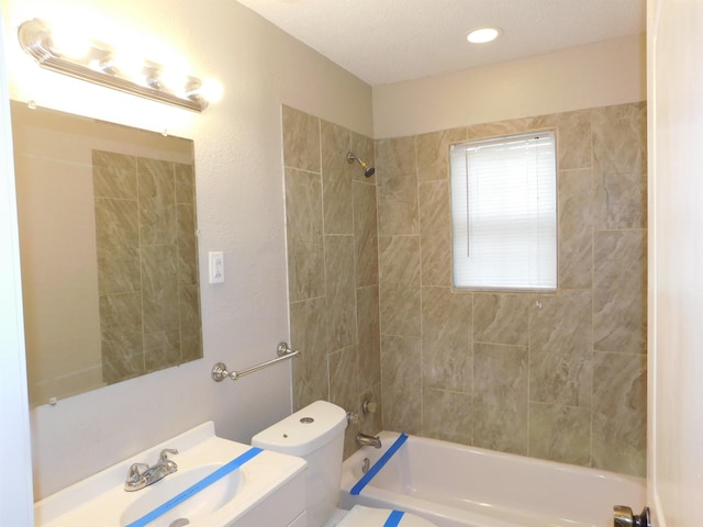 full bathroom with toilet, vanity, and tiled shower / bath