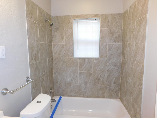 bathroom featuring toilet and tiled shower / bath