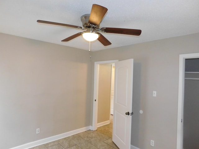 unfurnished bedroom featuring ceiling fan, light tile patterned floors, and a closet