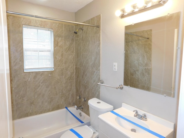 full bathroom featuring tiled shower / bath combo, vanity, and toilet