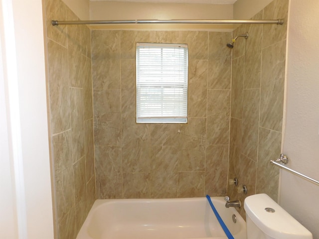 bathroom with tiled shower / bath combo and toilet