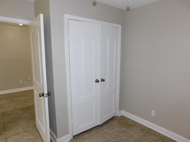 unfurnished bedroom featuring light tile patterned floors and a closet