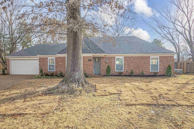 ranch-style home with a garage and a front lawn