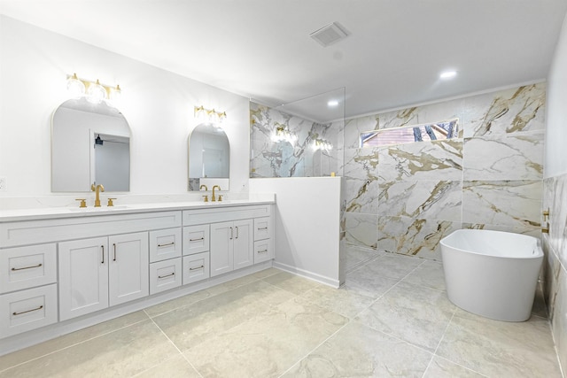 bathroom featuring shower with separate bathtub, tile walls, and vanity