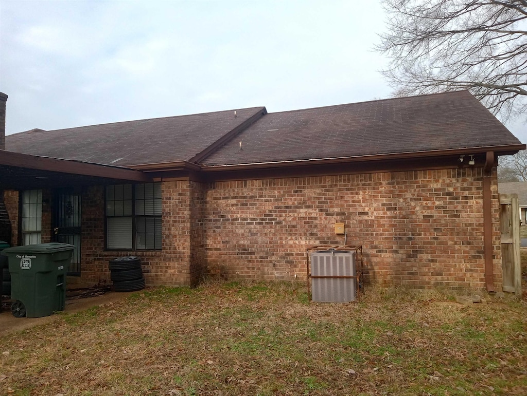 view of property exterior featuring a lawn and central AC