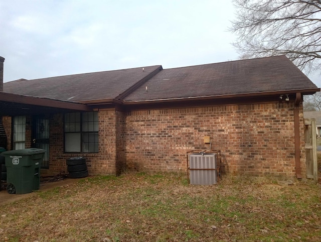 view of property exterior featuring a lawn and central AC