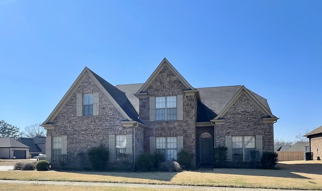 view of front of property featuring a front lawn and central AC