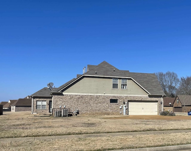 rear view of house featuring a garage and a yard