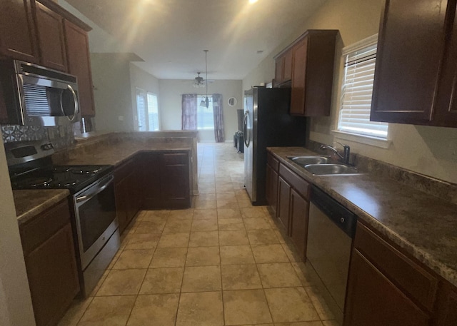 kitchen with stainless steel appliances, a healthy amount of sunlight, kitchen peninsula, and sink