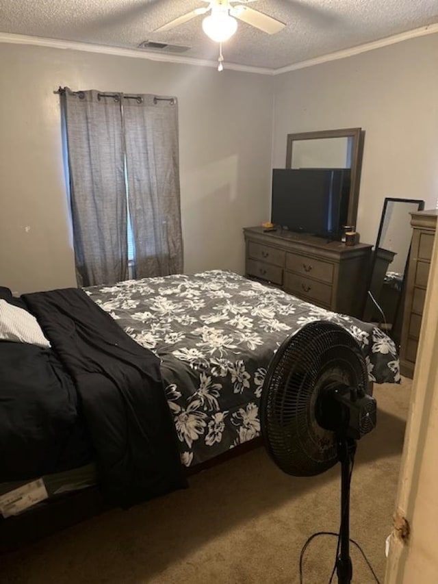 bedroom with a textured ceiling, ceiling fan, carpet, and ornamental molding