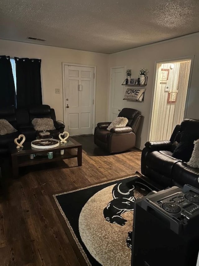 living room featuring wood-type flooring and a textured ceiling