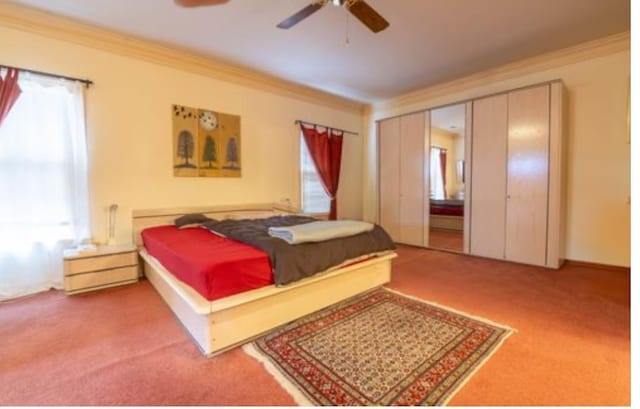 bedroom with ceiling fan, carpet, and ornamental molding