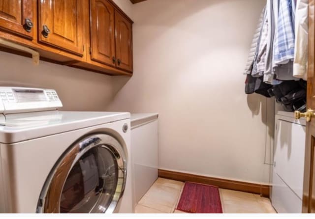 clothes washing area with independent washer and dryer and cabinets