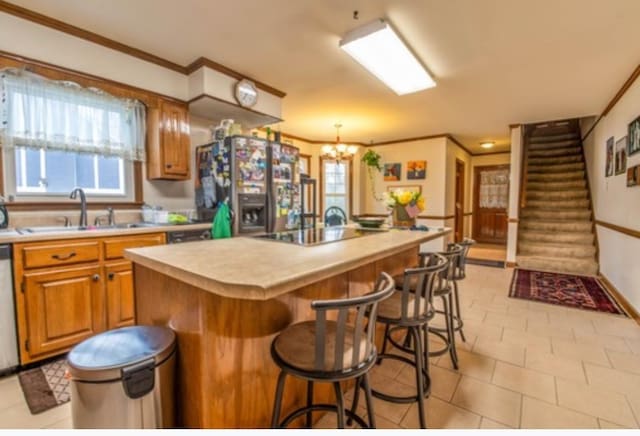 kitchen with a kitchen bar, sink, crown molding, an island with sink, and stainless steel appliances