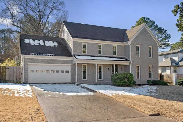 view of front facade featuring driveway, an attached garage, fence, a porch, and brick siding