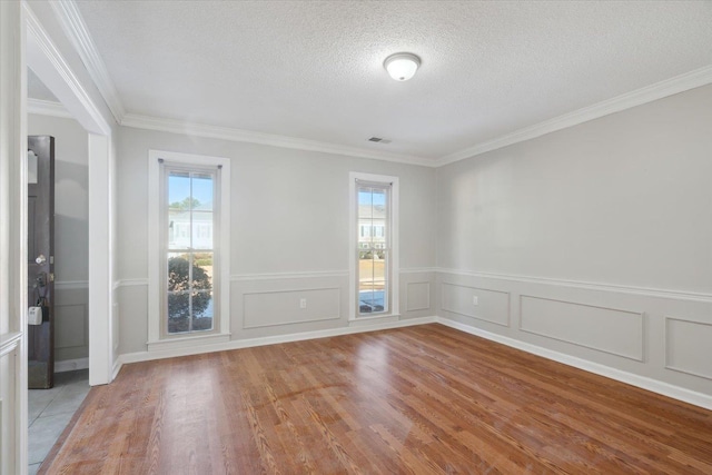 unfurnished room featuring light wood-style floors, visible vents, a healthy amount of sunlight, and a textured ceiling