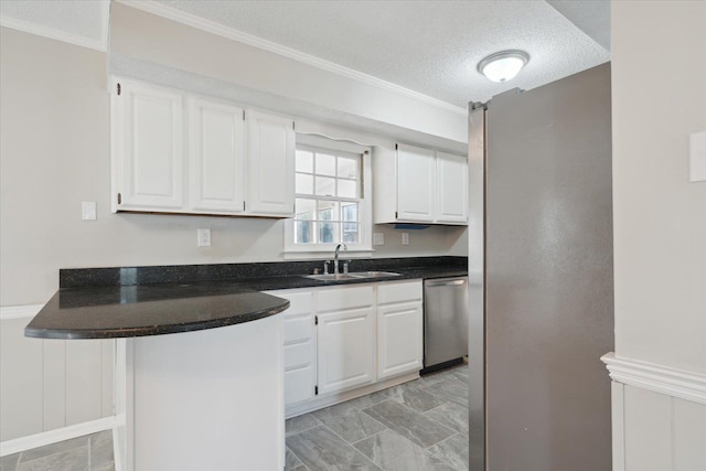 kitchen featuring dark countertops, dishwasher, white cabinets, and a sink