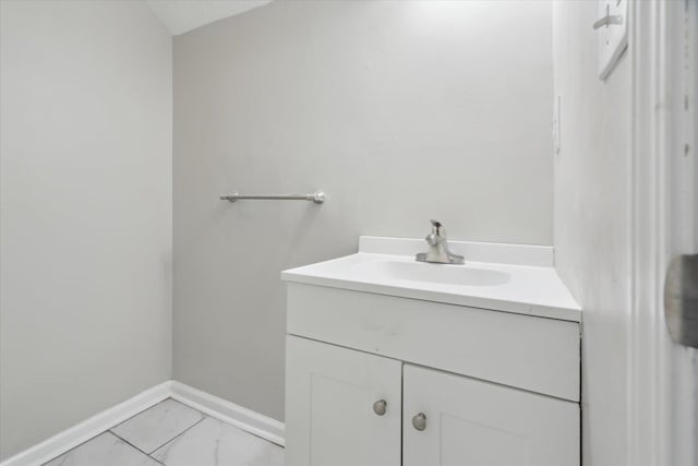 bathroom featuring marble finish floor, vanity, and baseboards