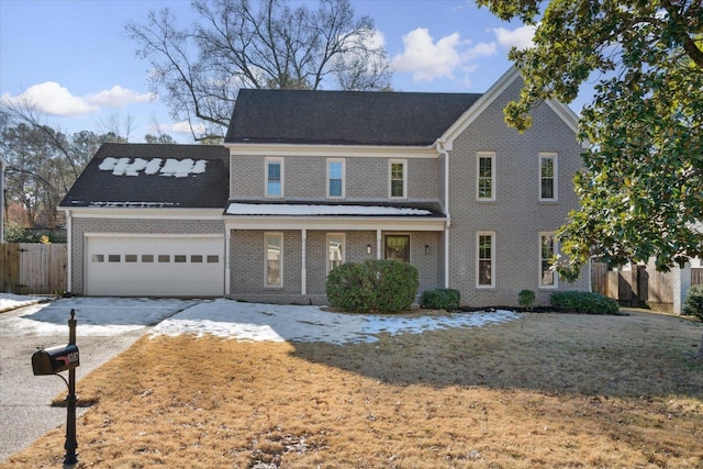 view of front facade with a garage, covered porch, and a front yard