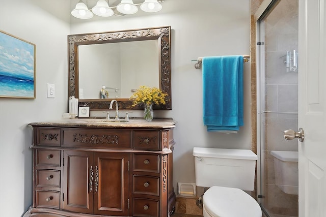 bathroom with a shower with shower door, vanity, and toilet