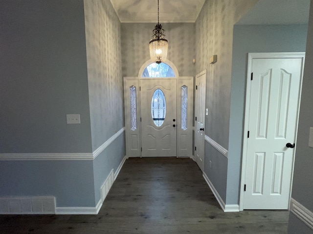 foyer entrance with a chandelier and dark hardwood / wood-style floors