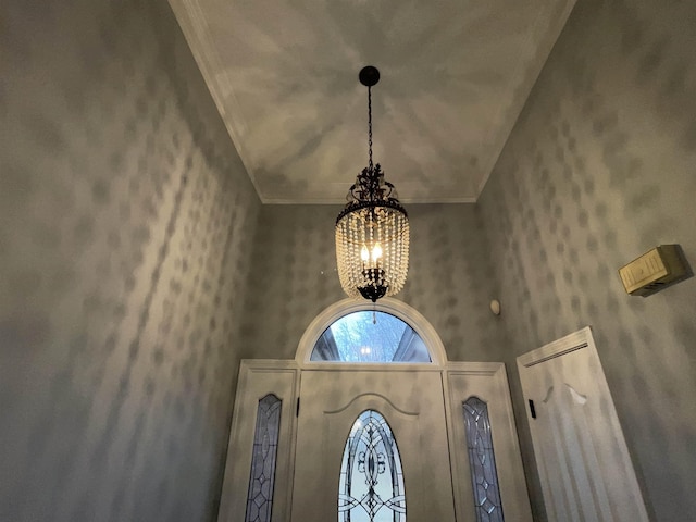 interior details with a chandelier and ornamental molding