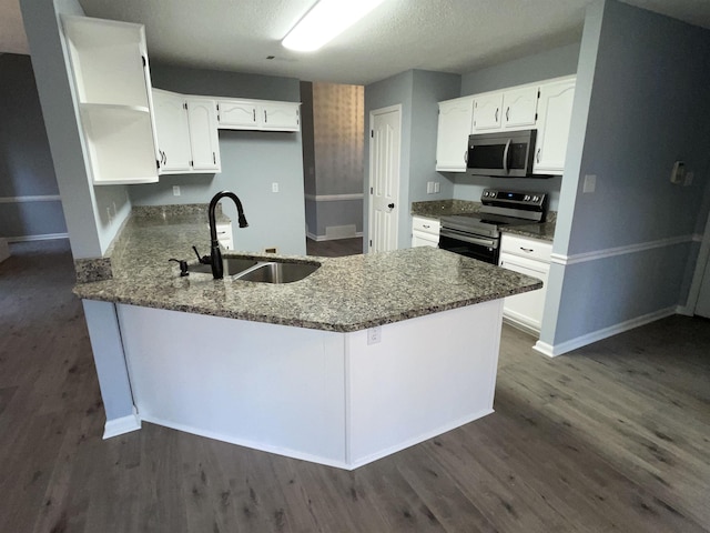 kitchen with sink, white cabinets, stainless steel appliances, and dark stone counters