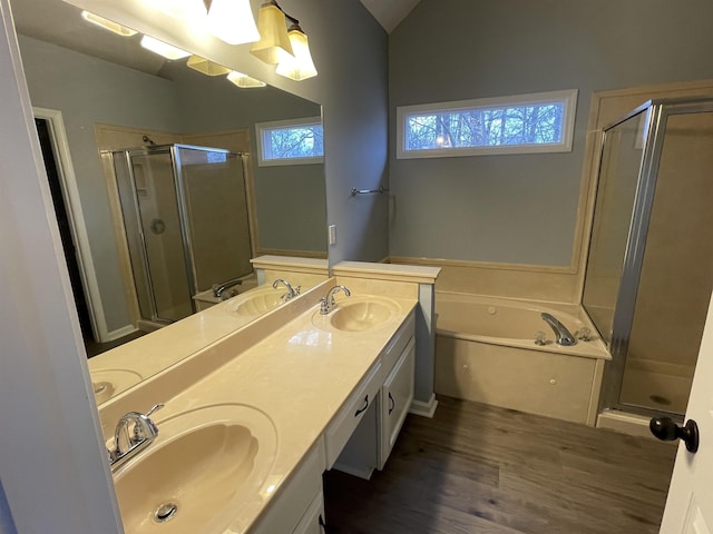 bathroom with vanity, vaulted ceiling, independent shower and bath, and hardwood / wood-style flooring