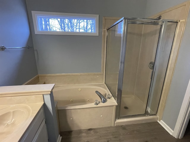 bathroom featuring hardwood / wood-style flooring, vanity, and shower with separate bathtub