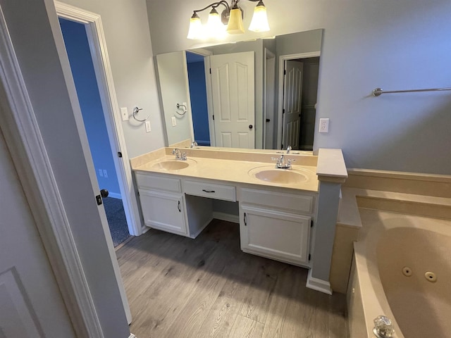 bathroom with a tub to relax in, vanity, and wood-type flooring