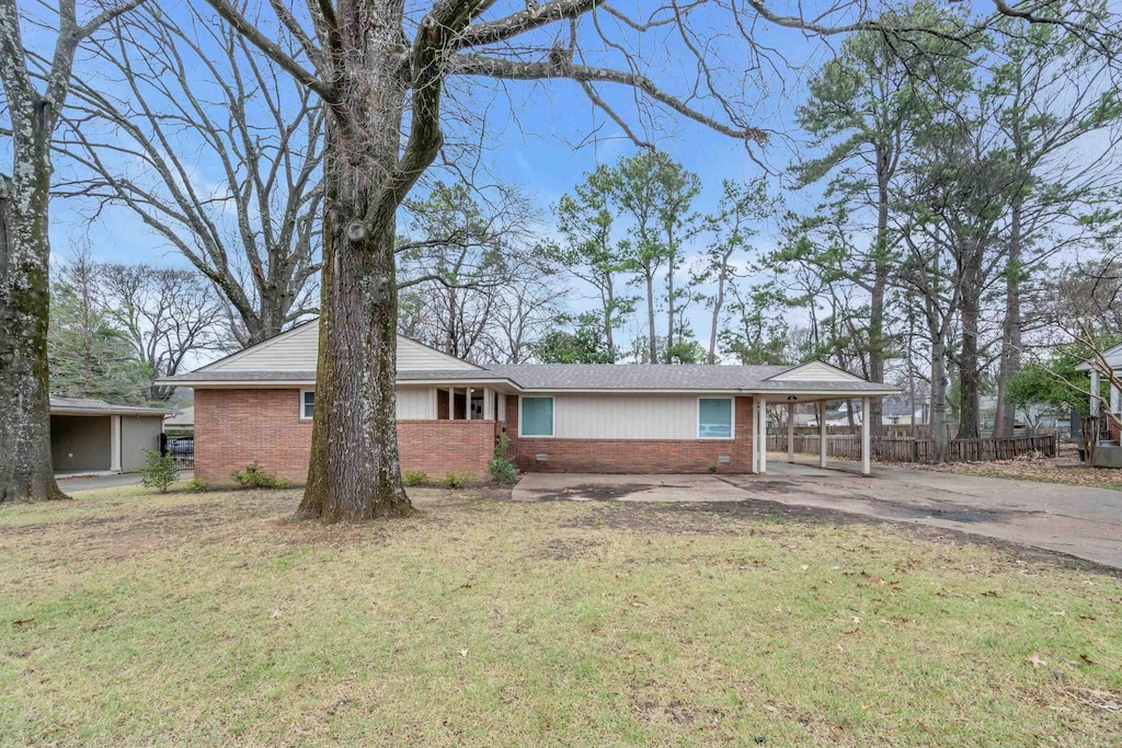 single story home featuring a front lawn and a carport