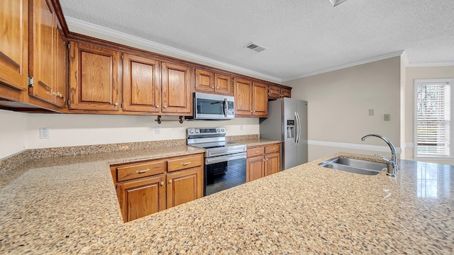 kitchen featuring sink, crown molding, appliances with stainless steel finishes, a textured ceiling, and light stone counters