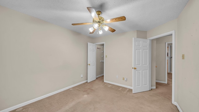 unfurnished bedroom with ceiling fan, a textured ceiling, and light carpet