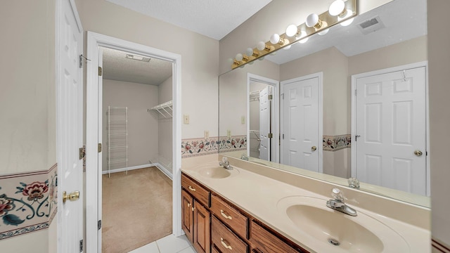 bathroom with vanity, tile patterned floors, and a textured ceiling