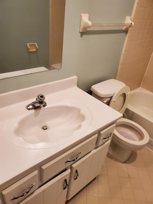 full bathroom with toilet, tiled shower / bath, tile patterned floors, and vanity