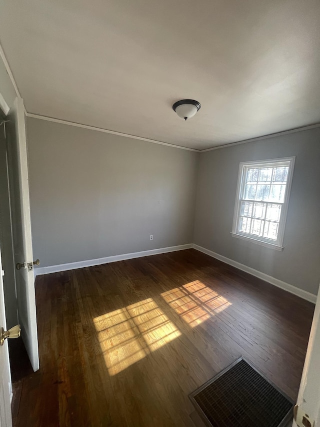 spare room featuring dark hardwood / wood-style floors and ornamental molding