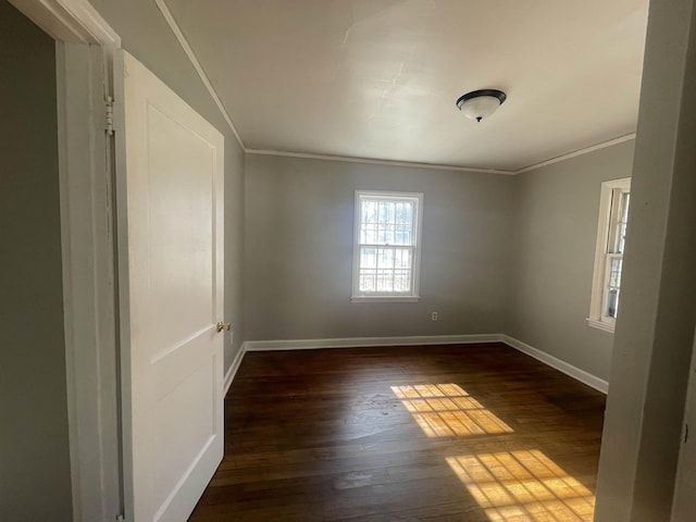 empty room with ornamental molding and dark hardwood / wood-style floors