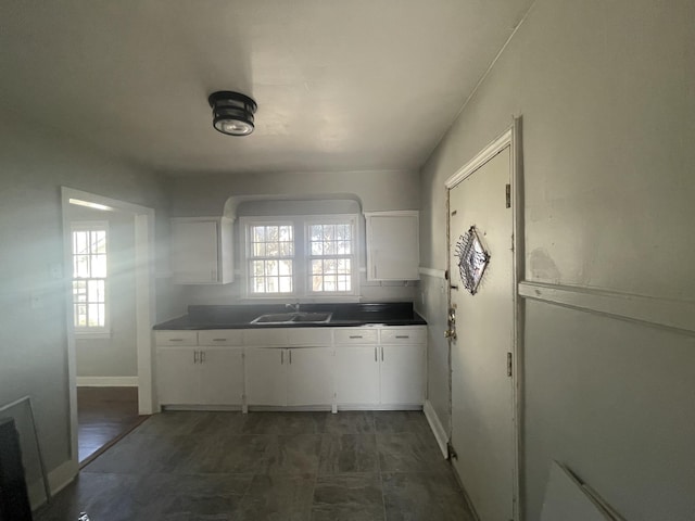 kitchen featuring plenty of natural light, backsplash, white cabinets, and sink