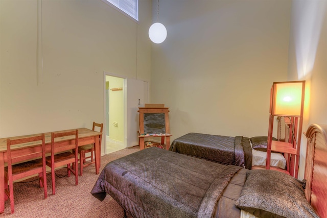 carpeted bedroom with a towering ceiling