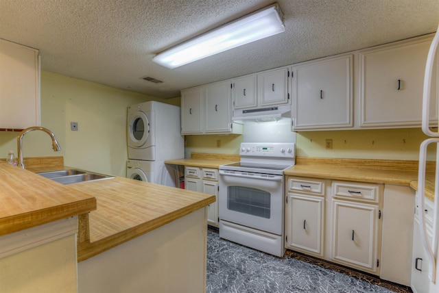 kitchen with stacked washer and dryer, white appliances, a textured ceiling, white cabinets, and sink