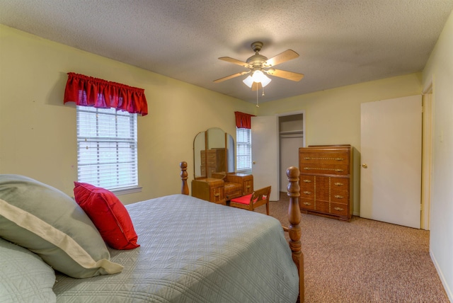 bedroom featuring a textured ceiling, ceiling fan, carpet flooring, and a closet