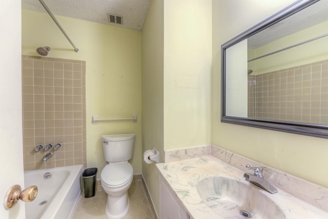 full bathroom with toilet, tiled shower / bath combo, tile patterned flooring, a textured ceiling, and vanity